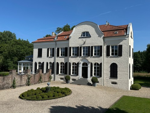 Weiß geschlämmtes Haus mit parkartigem Garten