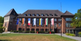 Gebäude mit mehreren gehissten Flaggen davor
