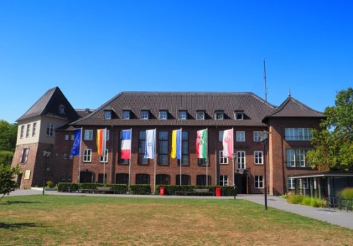 Gebäude mit mehreren gehissten Flaggen davor