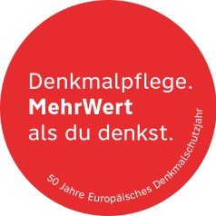 runder roter Button mit Slogan "Denkmalpflege. Mehr wert als Du denkst."