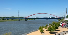 sich &uuml;ber einen breiten Fluss spannende, von Autos befahrene Bogenbr&uuml;cke