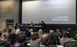 Podiumsdiskussion: fünf Personen auf dem Podium der Aula des Ingenieurwissenschaftlichen Zentrums der Technischen Hochschule Köln vor einem gut besetzten Auditorium