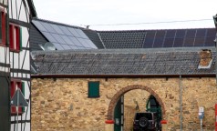 Tordurchfahrt zu einer Hofanlage mit einer Solaranlage auf dem Dach