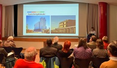 Vortragssaal mit Referentin und interessiertem Publikum