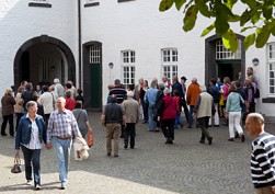 wandelnde Besucherinnen und Besucher im Wirtschaftshof der Abtei Brauweiler