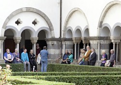 im Kreuzgang rastende Besucher mit Führendem
