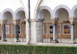 Durchblick durch die Bögen des romanischen Kreuzganges der Abtei Brauweiler auf eine Fotoausstellung zum Thema "Farbe!"