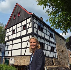 Lächelnde Frau vor Fachwerkhaus